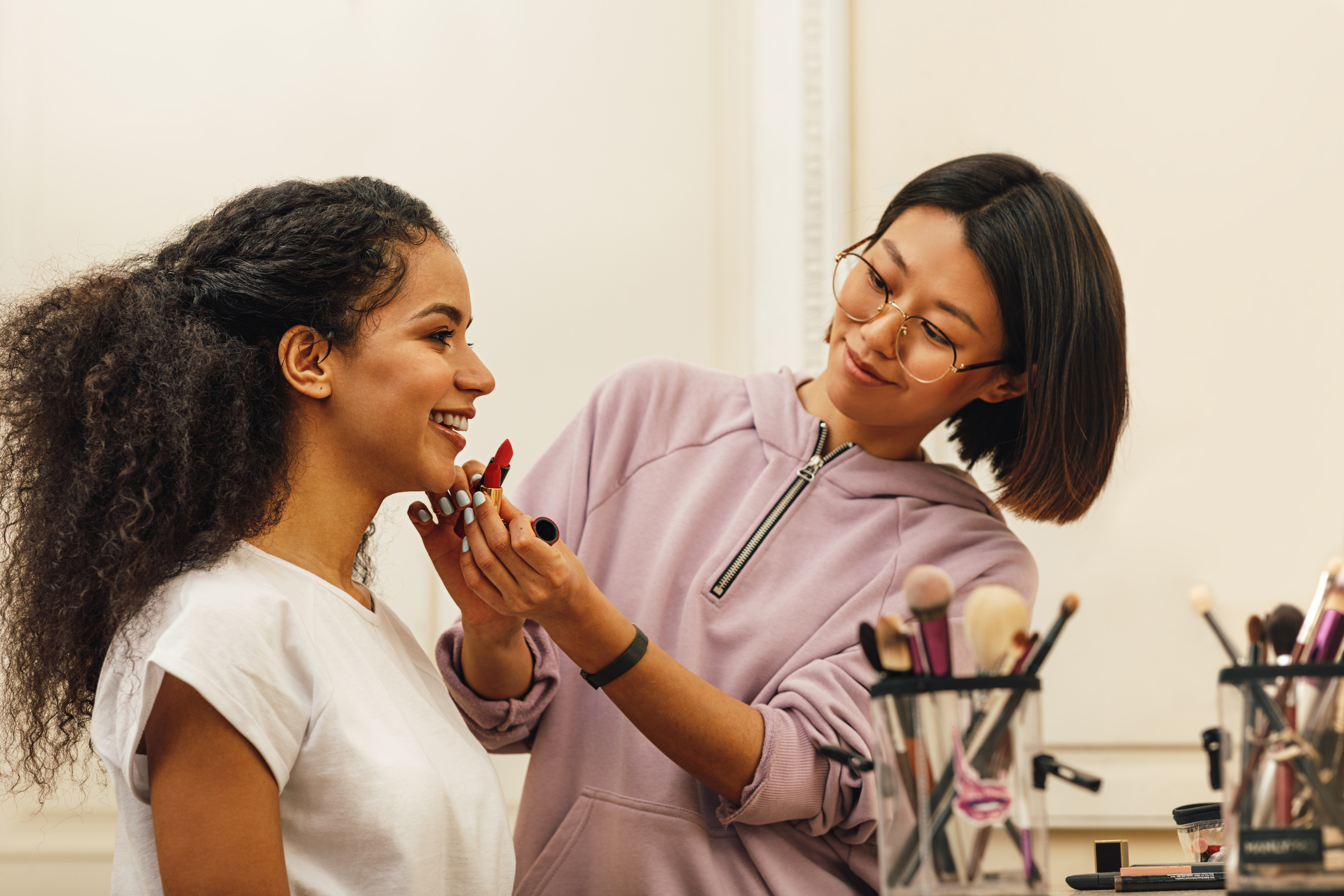 Make-up Artist Putting Lipstick on Young Woman