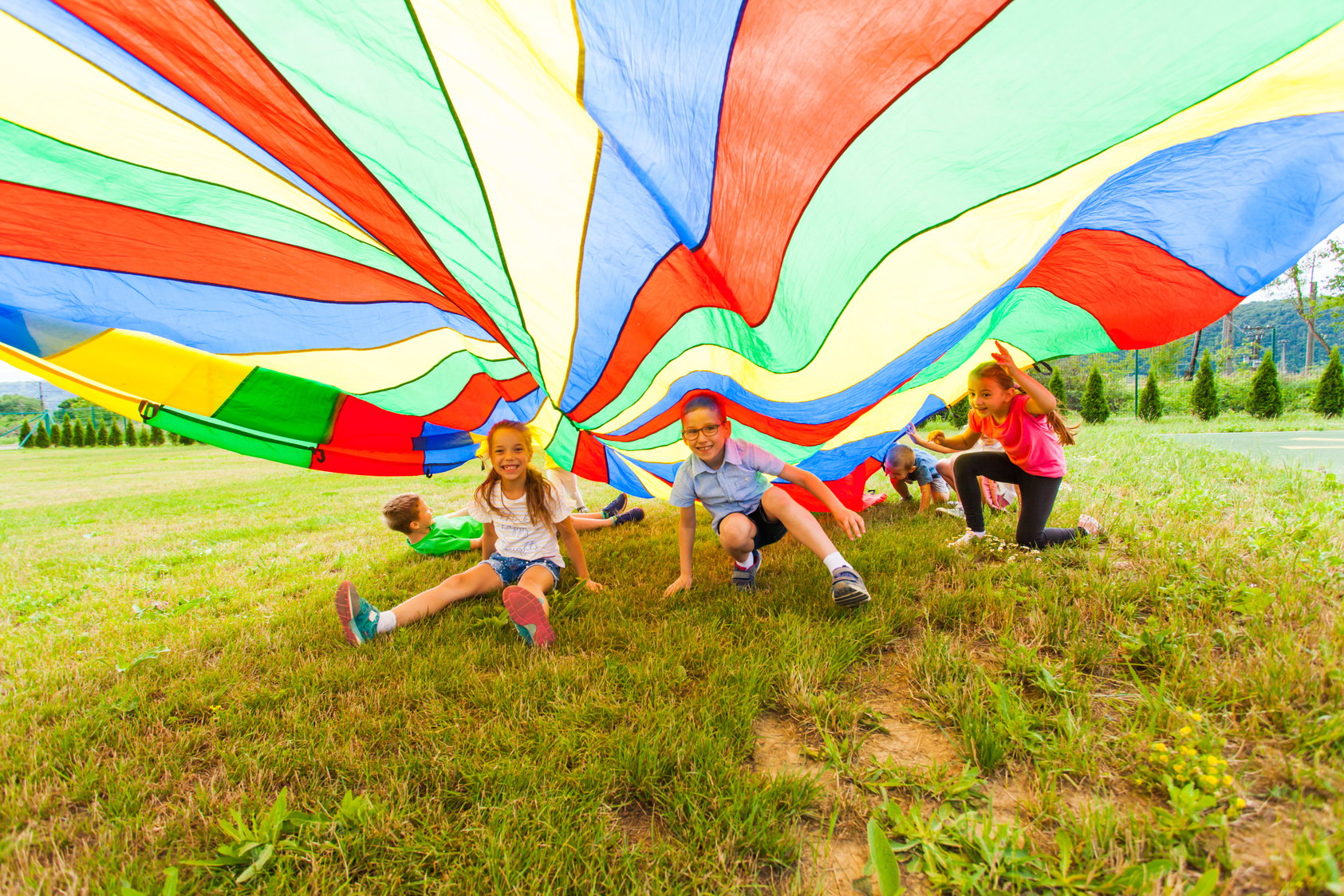 Smiling Boy and Girls under Colorful Parachute